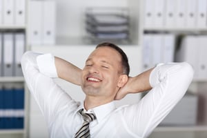 Smiling businessman sitting and relaxing at the office