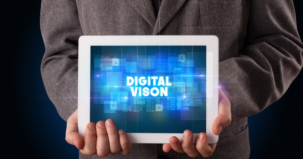 Young business person working on tablet and shows the inscription DIGITAL VISON
